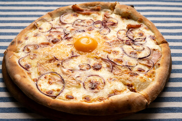 Carbonara pizza with bacon and egg yolk on table top view