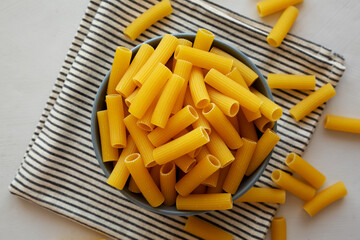 Dry Rigatoni Pasta in a Bowl, top view. Flat lay, overhead, from above. Close-up.