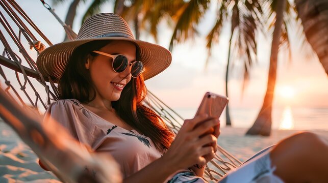 Working remotely Young happy woman female freelancer in straw hat and sunglasses working on smartphone while relaxing in the hammock on the beach at sunset Distance job during vacation : Generative AI