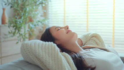 Relaxed young asian woman on comfortable sofa at home, female enjoying carefree peaceful weekend relaxation time alone in living room.