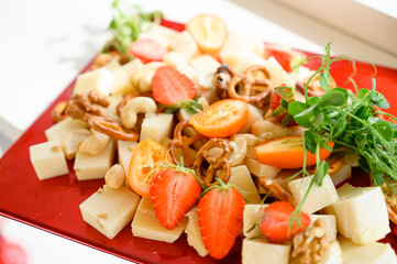 Cheese plate with cashews, bagels and strawberries