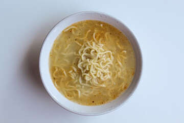 A serving of instant soup noodles, on white bowl, isolated on white background, flat lay or top view