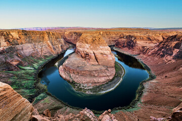 Dramatic Horseshoe Bend Arizona with Colorado River flowing around the island that formed millions...