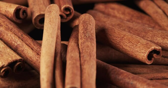 Cinnamon sticks rotate as a background. Fragrant cinnamon close-up. Spices with cinnamon. Food cooking video concept.