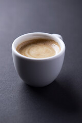 Cup of coffee on dark paper background. Soft focus. Close up. Copy space.