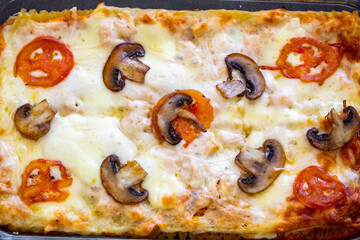 Traditional chicken lasagna with cheese and mushrooms