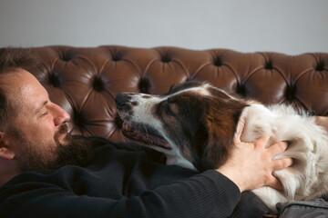 Man sitting on the sofa with his dog.