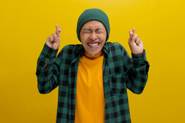Excited young Asian man, dressed in a beanie hat and casual shirt, expresses enthusiasm by making a...