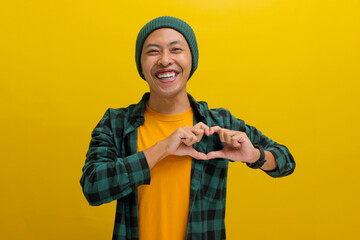 Attractive Asian man, dressed in a beanie hat and casual shirt, exudes happiness as he creates a...