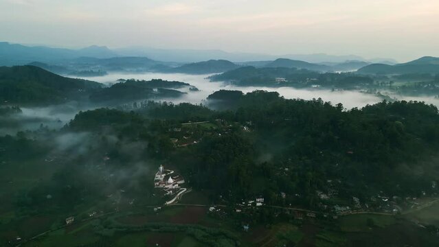 Drone flight above mist covered Haputale mountains at dawn. Misty highlands, rich green slopes, tea gardens, rural landscape. Peaceful, scenic nature footage for travel, eco tourism, meditation.