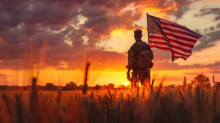 A soldier standing in a wheat field holding an American flag at sunset with a dramatic sky.