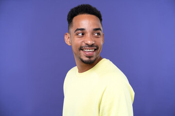 Emotional young black guy in casual raising fists up studio background, celebrating success