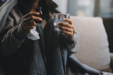 Upset woman frustrated by problem with work or relationships, sitting on couch, embracing knees,...