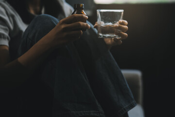 Upset woman frustrated by problem with work or relationships, sitting on couch, embracing knees,...