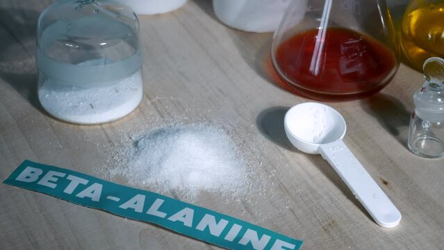Sports supplement, amino acid, beta-alanine. Powder on a laboratory table. Sports nutrition and health concept.