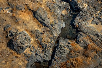 Aerial view of a hunter stealthily navigating through a rugged terrain, blending into the natural environment 