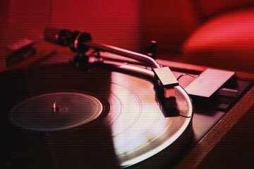 Vinyl record disc playing on turntable; retro style music player 