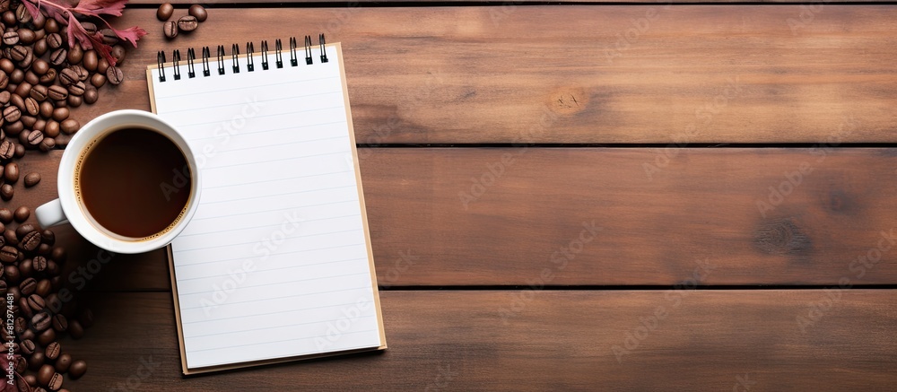Poster a copy space image of a notepad resting on a wooden table accompanied by a cup of coffee