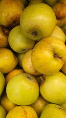 Close up pile of tasty fresh apples sold at the market as a background.