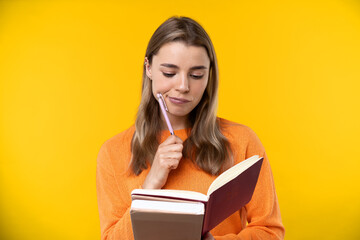 Happy emotions concept. Positive and beautiful young woman in studio with a notebook