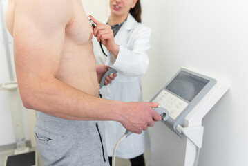 Slim male patient undergoing body composition measurement by healthcare professional