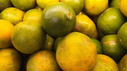 Close up pile of tasty fresh oranges sold at the market as a background.