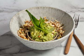 Vegan appetizer with smashed avocado, lettuce leaves, sprouted grains and beans, smoked tofu,...