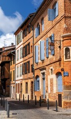 Fototapeta premium picturesque city street in the historic city center of Albi with the typical red brick buildings