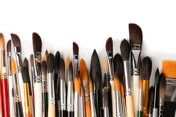 Mix of paint brushes in a row isolated on a white background.  Top view.