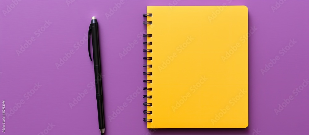 Poster copy space image featuring a purple notebook accompanied by a pen placed on a vibrant yellow backgro