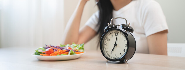 Intermittent fasting with clock, close up young woman, girl diet, waiting time to eat ketogenic low...