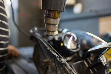 Person fixing Automotive lighting with screwdriver on Motor vehicle headlight