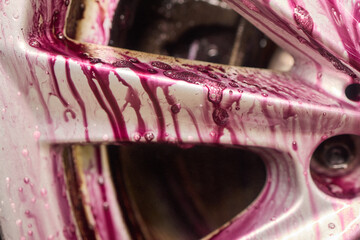 Closeup of automotive tire with water drops on rim and spokes