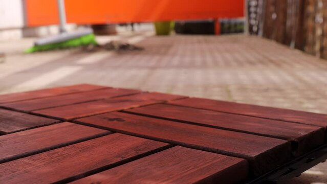 Prepare the balcony for installation of a wooden and artificial grass tile covering. sweeping taking place in the background. wooden tiles for the balcony
