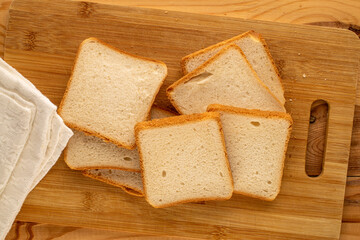 Several pieces of white bread for toaster on a wooden table, macro, top view.