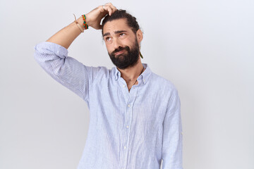 Hispanic man with beard wearing casual shirt confuse and wondering about question. uncertain with...