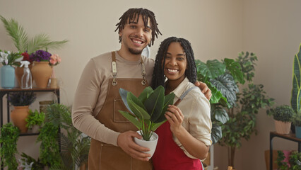 Man and woman florists smiling in a plant-filled flower shop