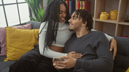 A loving couple embraces while relaxing on a sofa in their cozy living room, surrounded by warm decor.