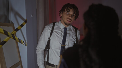 Woman and man investigators with badges in dark crime scene room