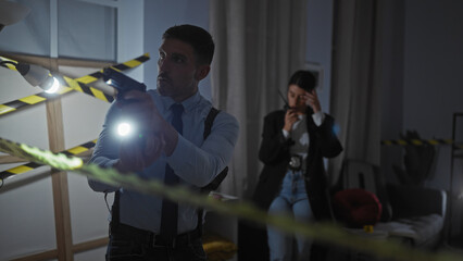 A policewoman and a man investigate a crime scene indoors, with a flashlight and caution tape...