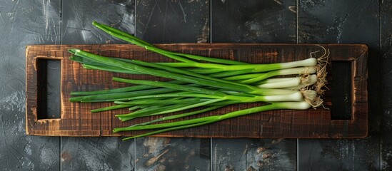 vegetable loncang Wooden board and bowl with fresh green onions on tile background