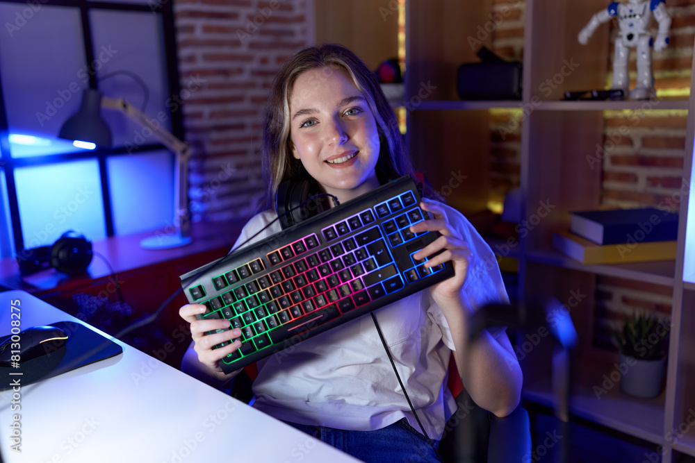 Poster young caucasian woman holding gamer keyboard smiling with a happy and cool smile on face. showing te