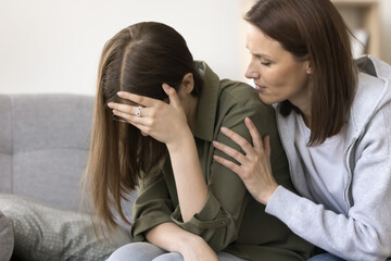 Worried sympathetic mom hugging crying teenager kid, helping to cope with stress, depression,...