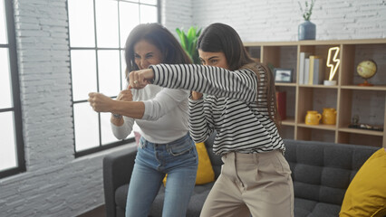 Mother and daughter engage in playful boxing stance, smiling in a cozy living room, depicting a...