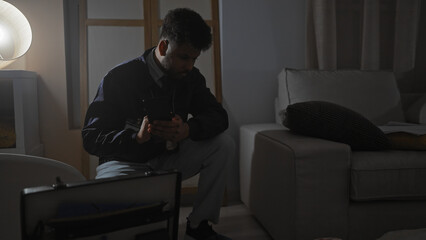 An african american man sits pensively in a dimly-lit room, reflecting on case clues.