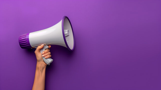 A hand is shown holding a megaphone against an purple background, symbolizing communication or announcement. The image is dynamic and attention-grabbing, with copy space