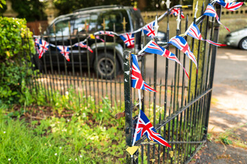 Shallow focus of Union Jack bunting seen strewn over the wrought iron entrance of an English...