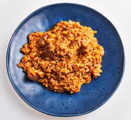 A savory plate of risotto served on a blue ceramic dish, highlighting italian cuisine.