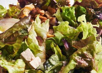 Close-up of a fresh mixed salad with lettuce, chicken, nuts, and healthy greens, ideal for...