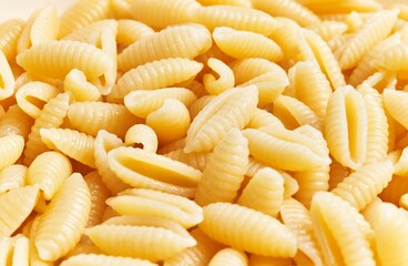 Close-up of uncooked fusilli pasta against a light background suitable for culinary themes.
